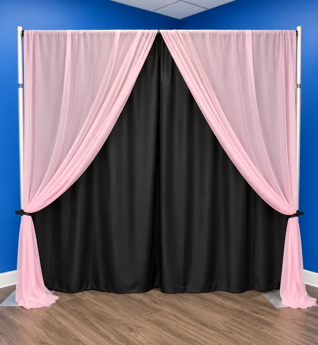 Pink sheer drapes tied back over black